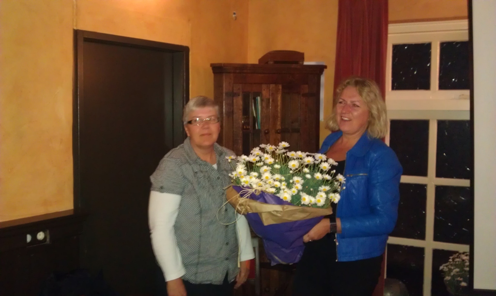 Berthie Berenpas overhandigd Jannie Nijkamp een bloemetje